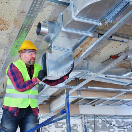 Manual Worker  installing air conditioner in building.